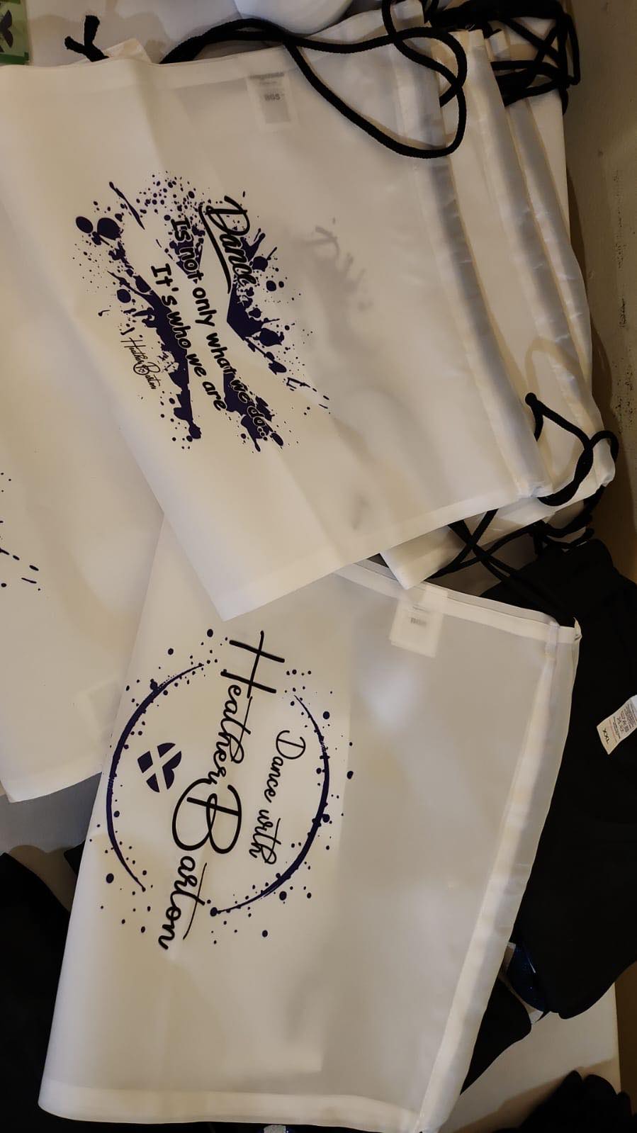 a photo of white drawstring bags with Dance with Heather Barton and a dance related quote